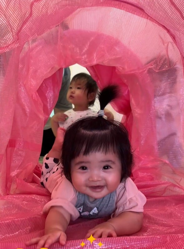 ピンク色のトンネル遊びを楽しむ子どもたち