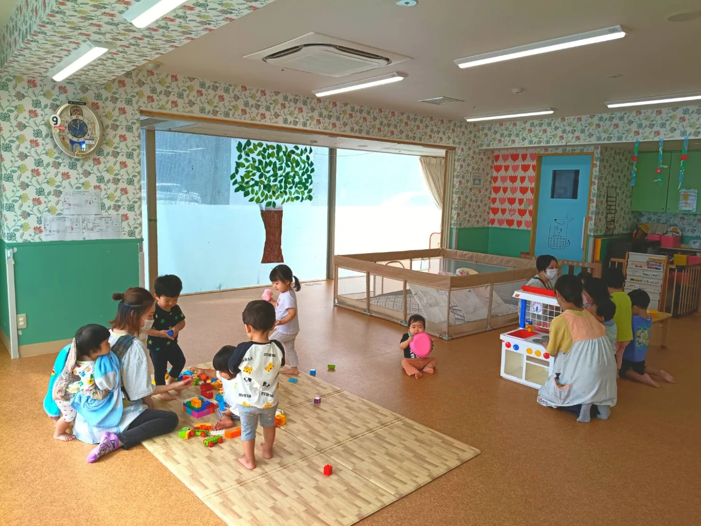 明るい保育室で遊ぶ子どもたち
