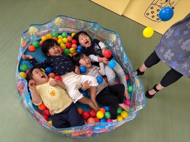 ボールプールで一緒に遊ぶ子どもたち