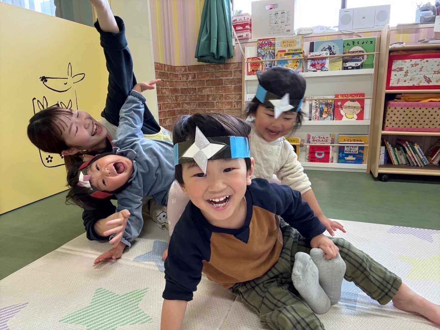 先生と一緒にお面をつけて遊ぶ子どもたち