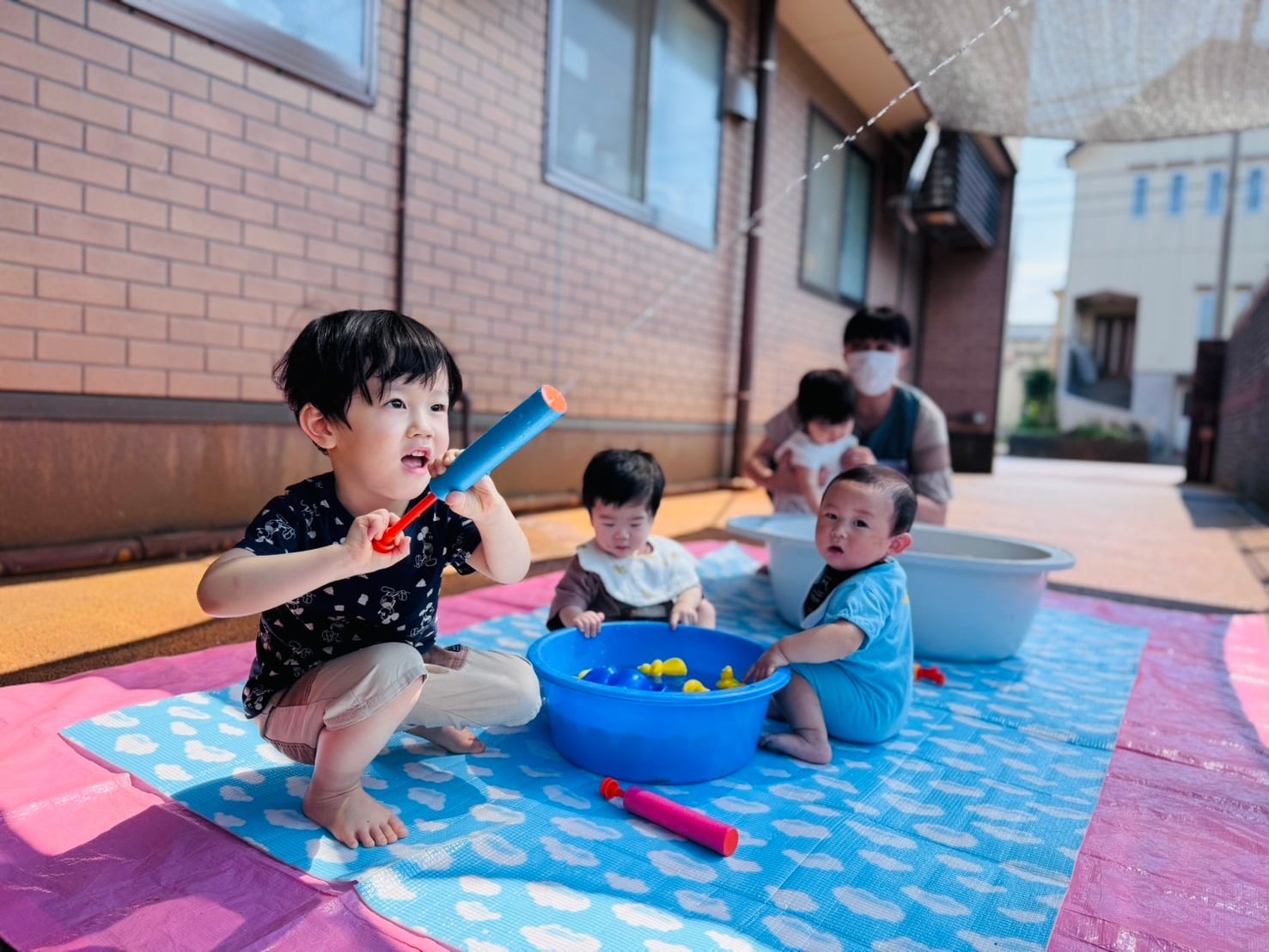 園庭で水遊びを楽しむ子どもたち