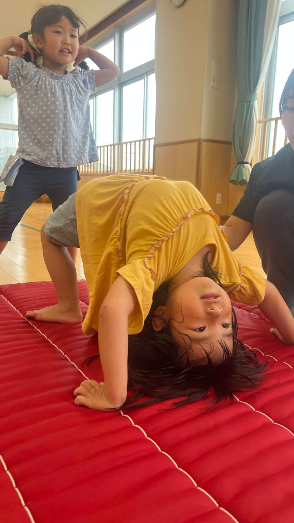 マットの上で体を動かして遊ぶ子ども