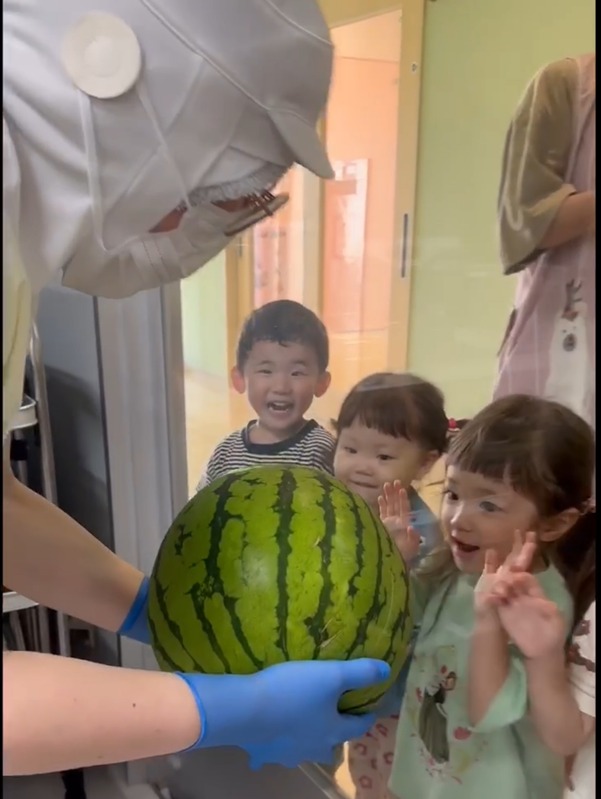 大きなスイカに触れて食育を楽しむ子どもたち